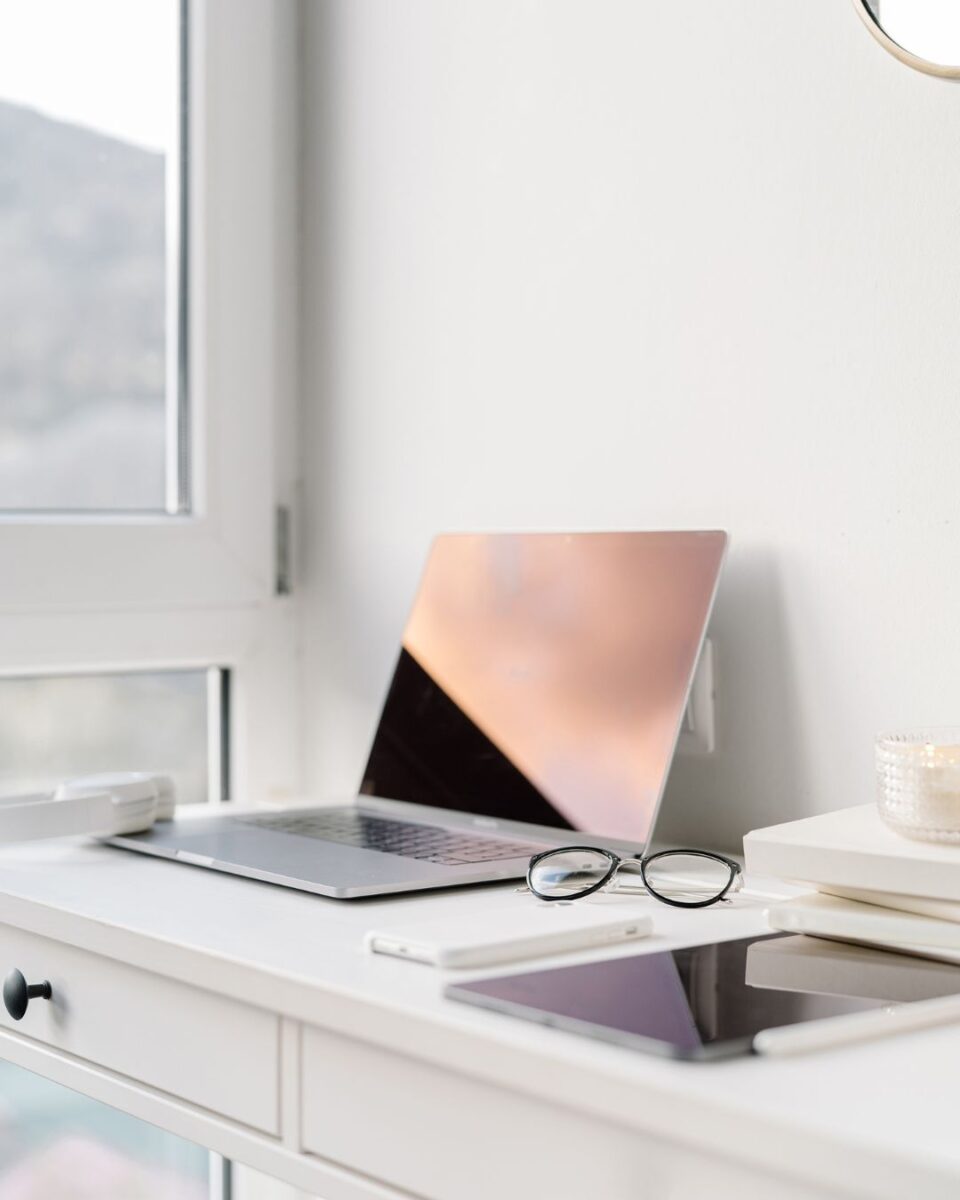 Ordinateur avec reflet d'un couché de soleil sur l'écran sur bureau blanc d'un expert seo et stratégie de contenu