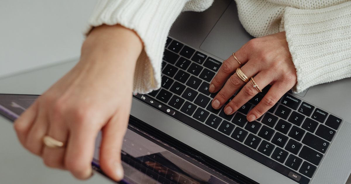 Une femme travaille sur son ordinateur et cherche comment utiliser les mots clés courte traîne et les mots clés longue traîne